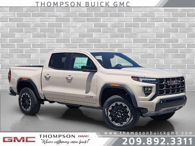 2026 GMC Canyon AT4 in Coastal Dune — front three-quarter view