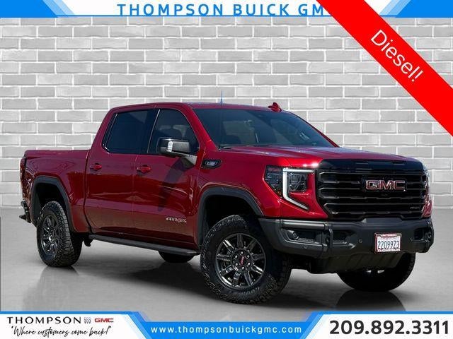 2024 GMC Sierra 1500 AT4X in Volcanic Red Tintcoat — front three-quarter view